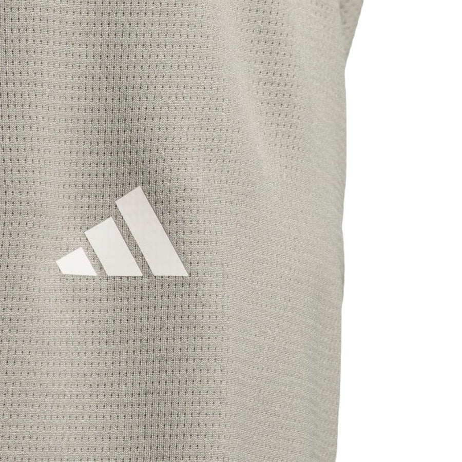 Close-up of the Adidas Lightweight Half-Zip Top - Final Sale in light grey, featuring a textured fabric made with recycled materials and a white adidas logo with three diagonal stripes.