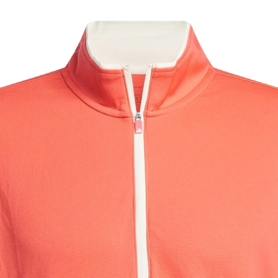 A close-up of the Adidas Lightweight Half-Zip Top, coral-colored with a white zipper and stand-up collar, crafted from recycled materials, displayed on a mannequin against a white background. Final Sale.