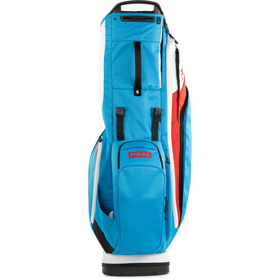The Ping Hoofer 231 Golf Carry Bag in blue has black handles, red and white accents, and stands upright. This lightweight bag features 16 zippered compartments, offering optimal organization for your golf gear.