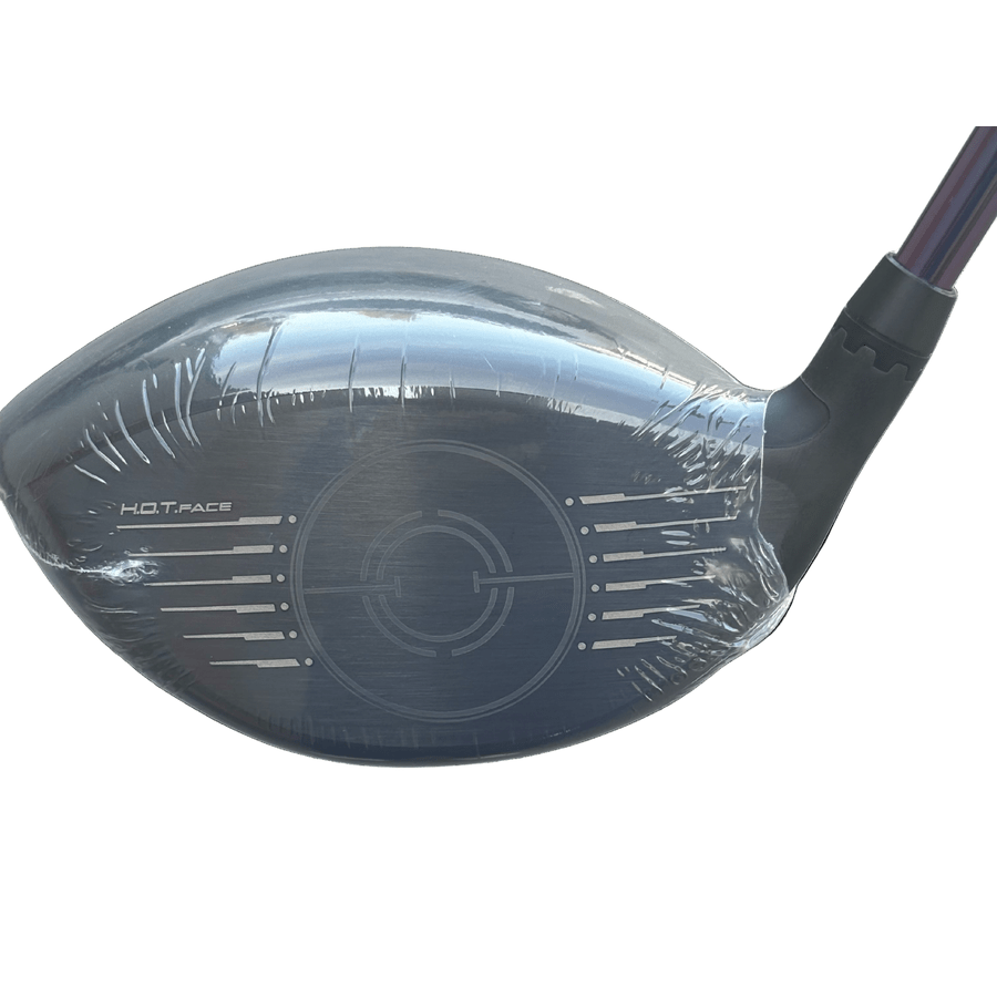 A close-up of the Cobra Darkspeed Tour Issue Long Drive LS Driver head, wrapped in protective plastic, shows its metallic face with “H.O.T. FACE” text and alignment marks, paired with the HZDRUS Green Shaft for peak performance.