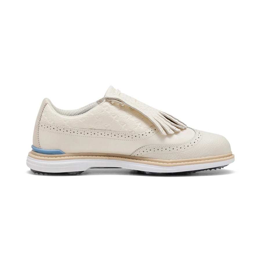 The Puma Arnold Palmer Royale Wingtip Golf Shoes - Ivory feature cream full-grain leather, perforated detailing, textured upper, kiltie fringe, tan midsole, white/blue outsole, low heel—seen side view as part of the PUMA x Arnold Palmer collection.