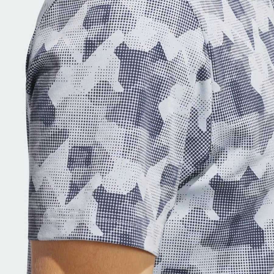 Close-up of the Adidas 2025 Go-To Printed Polo Shirt, showcasing a black and white abstract geometric pattern. Made with recycled materials, this men's golf shirt is shown worn on the arm and shoulder against a light background.